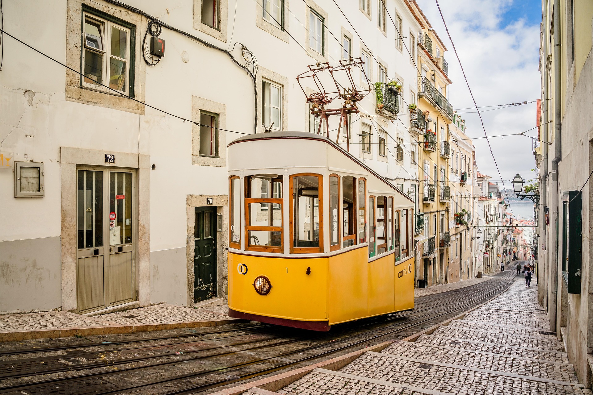 Tranvía amarillo circulando por las calles de Lisboa